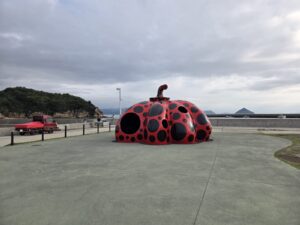 直島の海辺に設置された草間彌生の赤と黒の水玉模様の「赤かぼちゃ」