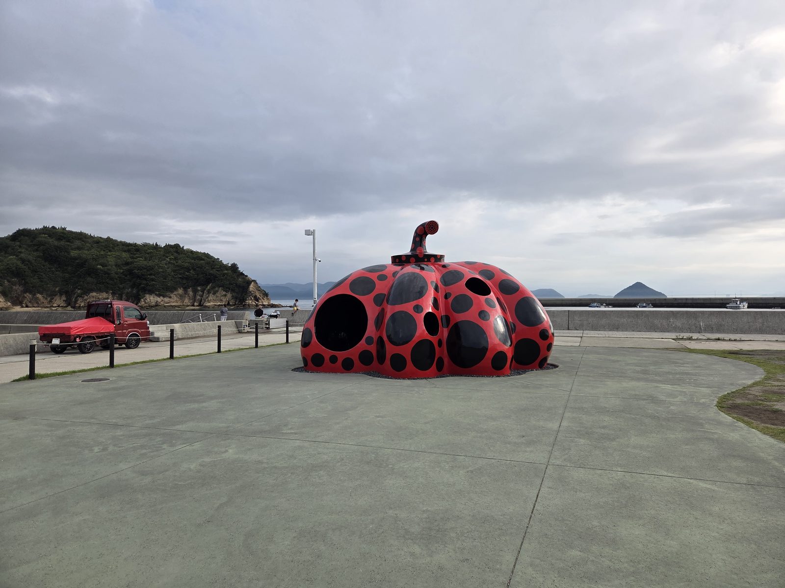 直島の海辺に設置された草間彌生の赤と黒の水玉模様の「赤かぼちゃ」